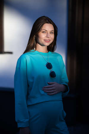 Portrait of a pretty attractive sexy young pregnant woman with natural makeup with beautiful eyes in a fashionable bright clothes. Girl is walking around the city.の写真素材