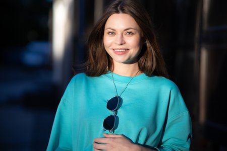 Portrait of a pretty attractive sexy young pregnant woman with natural makeup with beautiful eyes in a fashionable bright clothes. Girl is walking around the city.の写真素材