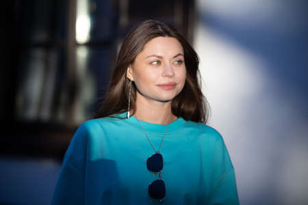 Portrait of a pretty attractive sexy young pregnant woman with natural makeup with beautiful eyes in a fashionable bright clothes. Girl is walking around the city.の写真素材