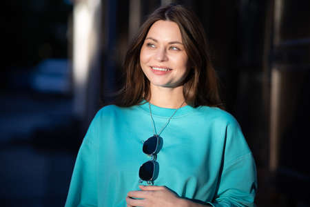 Portrait of a pretty attractive sexy young pregnant woman with natural makeup with beautiful eyes in a fashionable bright clothes. Girl is walking around the city.の写真素材
