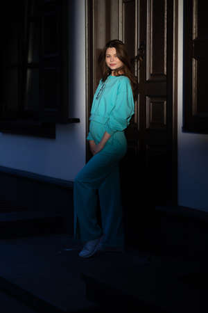 Portrait of a pretty attractive sexy young pregnant woman with natural makeup with beautiful eyes in a fashionable bright clothes. Girl is walking around the city.の写真素材