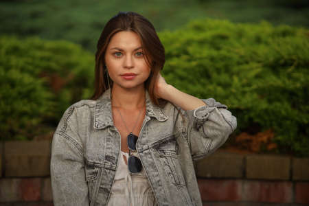 Gorgeous young pregnant woman in fashion jeans clothes in stylish dress has a good time in the park. Attractive girl model in casual outfit.の写真素材
