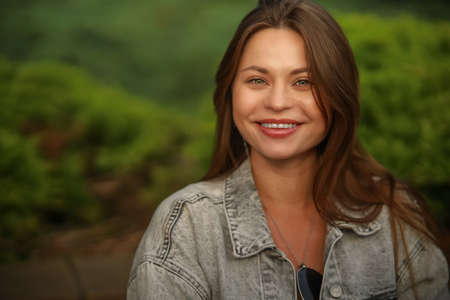 Gorgeous young pregnant woman in fashion jeans clothes in stylish dress has a good time in the park. Attractive girl model in casual outfit.の写真素材
