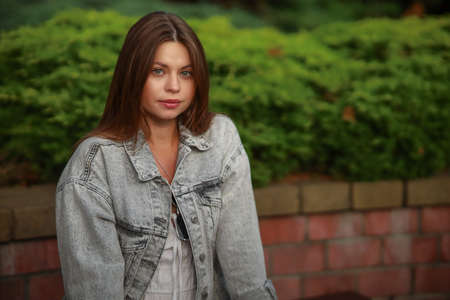 Gorgeous young pregnant woman in fashion jeans clothes in stylish dress has a good time in the park. Attractive girl model in casual outfit.の写真素材