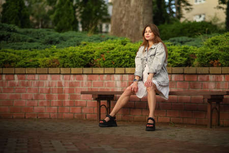 Gorgeous young pregnant woman in fashion jeans clothes in stylish dress has a good time in the park. Attractive girl model in casual outfit.の写真素材