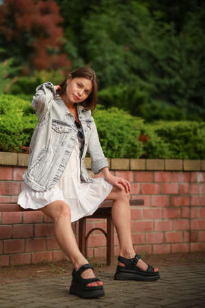 Gorgeous young pregnant woman in fashion jeans clothes in stylish dress has a good time in the park. Attractive girl model in casual outfit.の写真素材