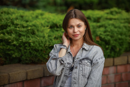 Gorgeous young pregnant woman in fashion jeans clothes in stylish dress has a good time in the park. Attractive girl model in casual outfit.の写真素材