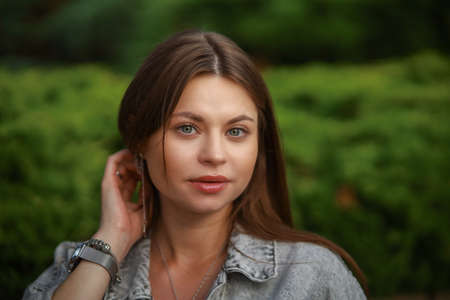 Gorgeous young pregnant woman in fashion jeans clothes in stylish dress has a good time in the park. Attractive girl model in casual outfit.の写真素材