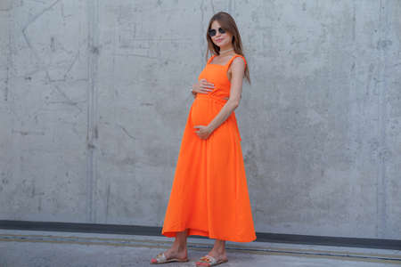 A young beautiful girl in stylish sunglasses and a bright stylish dress.の写真素材