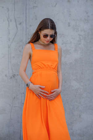 A young beautiful girl in stylish sunglasses and a bright stylish dress.