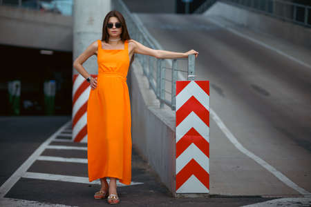A young beautiful girl in stylish sunglasses and a bright stylish dress.の写真素材