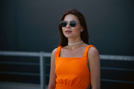 A young beautiful girl in stylish sunglasses and a bright stylish dress.の写真素材