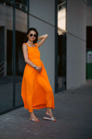 A young beautiful girl in stylish sunglasses and a bright stylish dress.の写真素材
