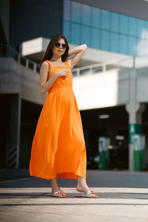 A young beautiful girl in stylish sunglasses and a bright stylish dress.の写真素材