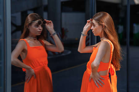 A young beautiful girl in stylish sunglasses and a bright stylish dress.
