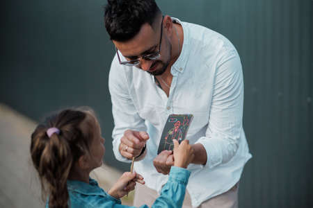 Father and daughter are walking together. Stylish young father having fun with his teenage daughter, the concept of a happy family.の写真素材
