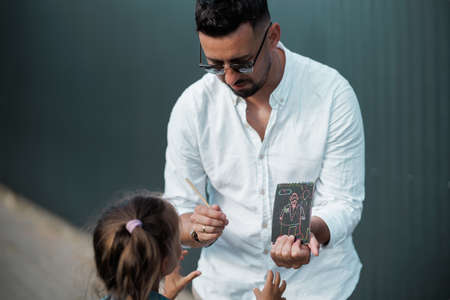 Father and daughter are walking together. Stylish young father having fun with his teenage daughter, the concept of a happy family.の写真素材