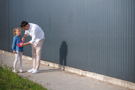 Father and daughter are walking together. Stylish young father having fun with his teenage daughter, the concept of a happy family.の写真素材