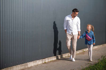 Father and daughter are walking together. Stylish young father having fun with his teenage daughter, the concept of a happy family.の写真素材