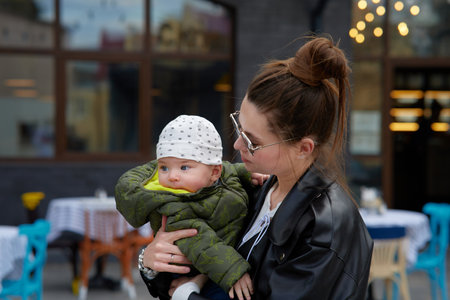 Young mother with her baby boy in a cafe on the street.の写真素材