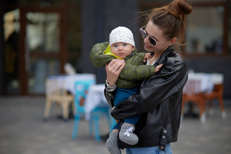 Happy mother with her little baby in a city street. Portraitの写真素材
