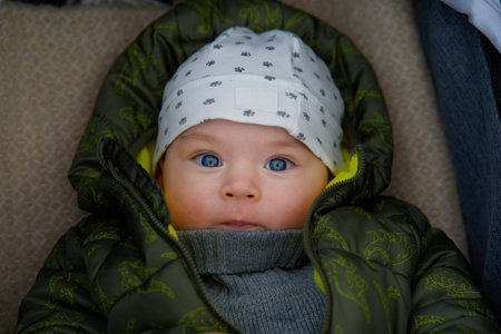 Portrait of a newborn baby boy with blue eyes in a winter capの写真素材