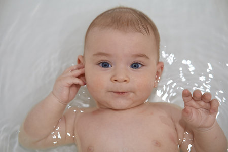 Portrait of a baby boy with blue eyes in the bath.の写真素材