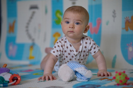 Cute baby boy playing with toys on the floor at home.の写真素材