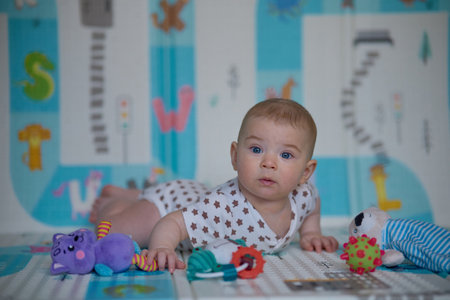 Portrait of a cute little baby boy playing with toys at homeの写真素材