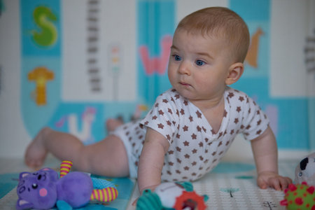 Cute little baby girl playing with toys on the floor in the roomの写真素材