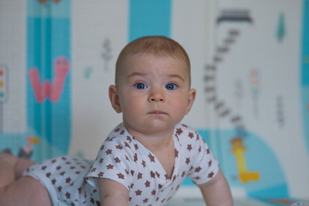 Portrait of a baby girl in a room with a blue backgroundの写真素材
