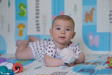 Cute baby girl playing with toys on the floor at home.の写真素材