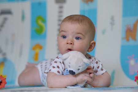 baby girl playing with toys on the floor in the room at homeの写真素材