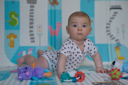 Portrait of a cute baby boy playing with toys in the roomの写真素材