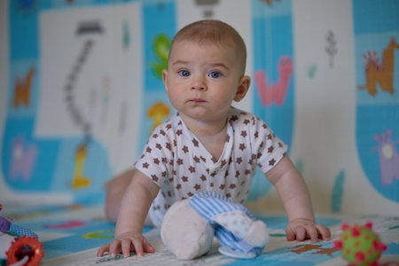 Portrait of a cute baby lying on the floor in the roomの写真素材
