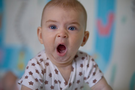 Portrait of a cute baby girl with blue eyes and a funny expressionの写真素材