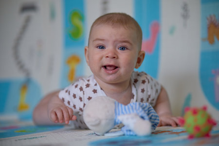 Portrait of a cute baby girl lying on the floor with toysの写真素材