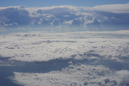 Clouds and sky as seen through window of an aircraft flying above the cloudsの写真素材
