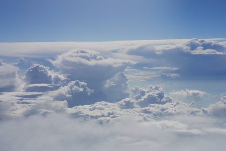 Clouds in the blue sky as seen through window of an aircraftの写真素材
