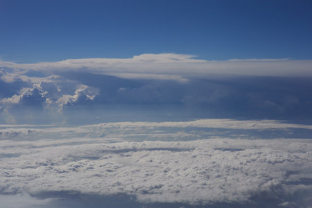 Clouds and sky as seen through window of an aircraft during flightの写真素材