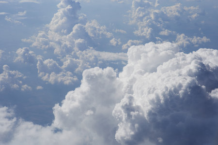 Cloudscape, view of blue sky and white clouds from airplane windowの写真素材