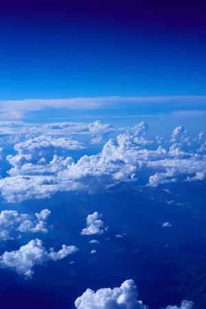 Clouds in the blue sky as seen through window of an aircraftの写真素材