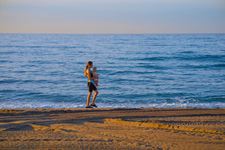 Young couple jogging on the beach at sunrise. Healthy lifestyle concept.の写真素材