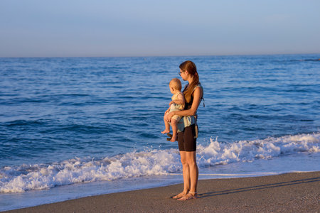 Mother and baby on the seashore. Young woman with a child on the beach.の写真素材