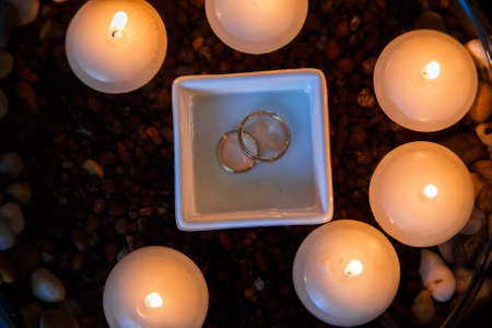 Wedding diamond ring with candles in the water.の写真素材