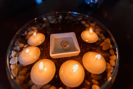 Wedding diamond ring with candles in the water.の写真素材