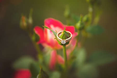 A gold ring with a diamond on a rose bud.
