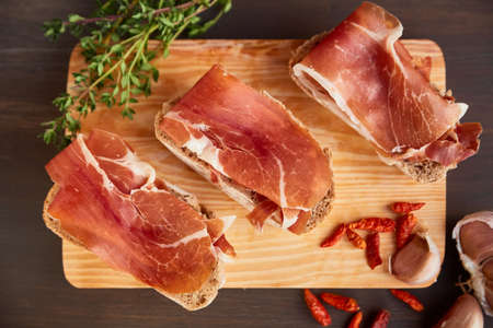 Sandwiches made from hand-made rye bread and thin chopped fresh bacon. Succulend bacon on a wooden...