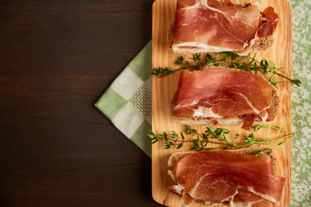 Sandwiches made from hand-made rye bread and thin chopped fresh bacon. Succulend bacon on a wooden...