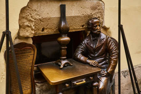 Lviv, Ukraine - November, 2017. Monument to the founder of the gas lamp in Lviv. A bronze statue of a sitting man at a table.のeditorial素材